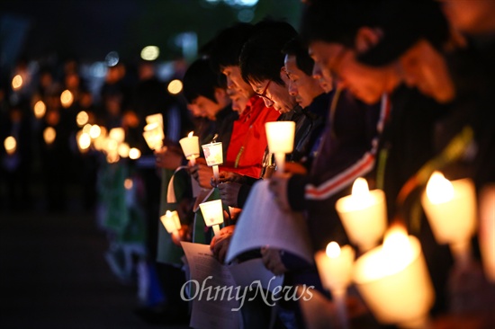 세월호 침몰사건 1주일째인 22일 오후 경기도 안산문화광장에서 열린 실종자 무사귀환과 희생자 추모를 위한 촛불문화제에서 참가자들이 묵념을 하고 있다.