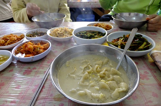 여러 가지 반찬들을 낯모르는 손님들과 함께 하며 먹는 들깨 수제비. 