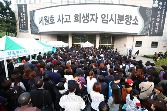 세월호 침몰사고 8일째인 23일 경기도 안산 올림픽기념관 내에 마련된 합동분향소 앞에서 조문을 기다리는 사람들이 줄을 서서 기다리고 있다.