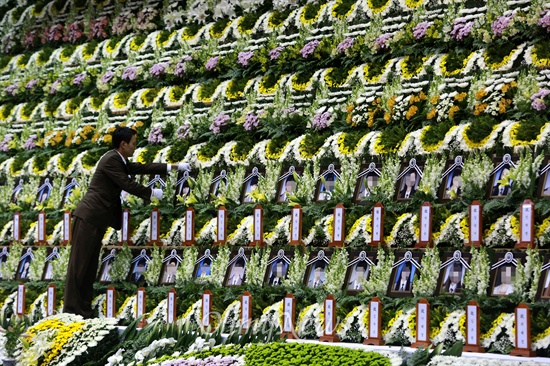 '세월호 침몰사고' 9일째인 24일 오후 경기도 안산시 올림픽기념관에 마련된 합동분향소에서 장례지도사가 영정을 정리하고 있다.