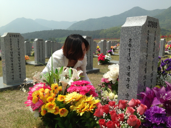 고 노우빈 일병의 어머니 공복순씨가 아들의 묘 앞에 꽃다발을 놓고 있다.
