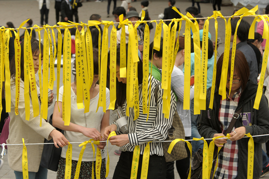 26일 오후 서울 중구 대한문 앞에서 많은 시민들이 '세월호 침몰사고'로 인한 희생자들을 애도하고 실종자들의 무사귀환을 염원하는 노란끈을 묶고 있다.
