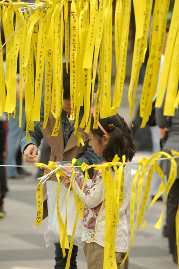 26일 오후 서울 중구 대한문 앞에서 시민들이 '세월호 침몰사고'로 인한 희생자들을 애도하고 실종자들의 무사귀환을 염원하는  노란끈을 묶고있다.
