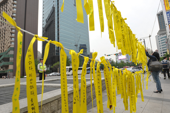 26일 오후 서울 중구 대한문 앞에서 많은 시민들이 '세월호 침몰사고'로 인한 희생자들을 애도하고 실종자들의 무사귀환을 염원하는 노란끈을 묶고 있다.