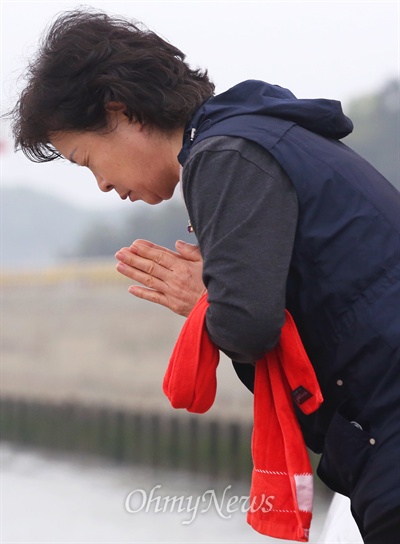 세월호 침몰사고 13일째인 28일 오전 비 내리는 팽목항을 뜨지 못하는 실종자 가족이 사고해역을 향해 간절히 기도하고 있다.