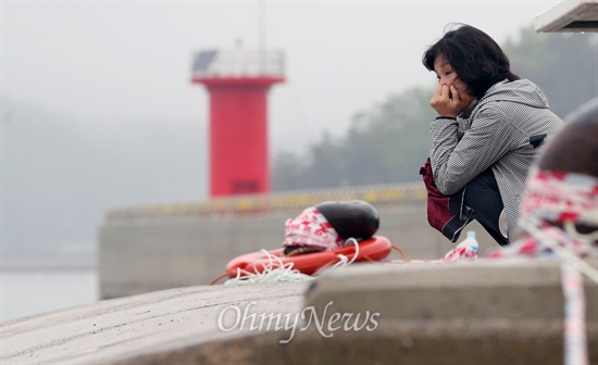 세월호 침몰사고 13일째인 28일 오전 비 내리는 팽목항을 뜨지 못하는 실종자 가족이 사고해역을 바라보며 소리없이 울고 있다. 
