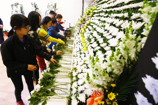 세월호 침몰사고 13일째인 28일 오전 전남 진도 향토문화회관에 마련된 합동분향소에서 진도 의신 초등학교 학생들이 헌화를 하고 있다.
