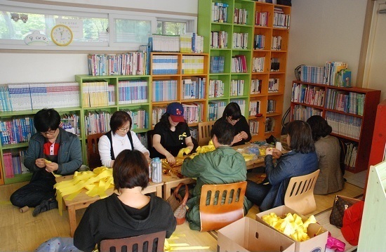와리마루 도서관에서 동네 어머니들이 단원고 학생들의 무사귀환을 염원하는 노란리본을 만들고 있다. 
