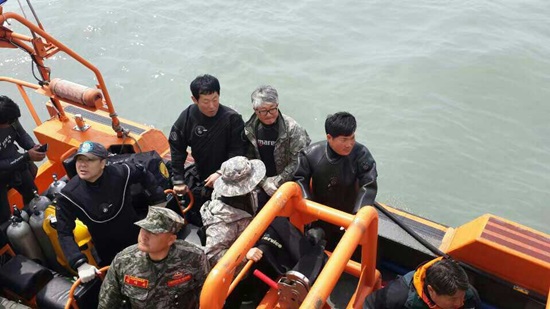 세월호 침몰 사고로 실종된 조카를 구하기 위해 민간잠수부로 활동중인 이모부 유지수(바깥 우측 첫번째)씨와 민간 잠수사의 모습
