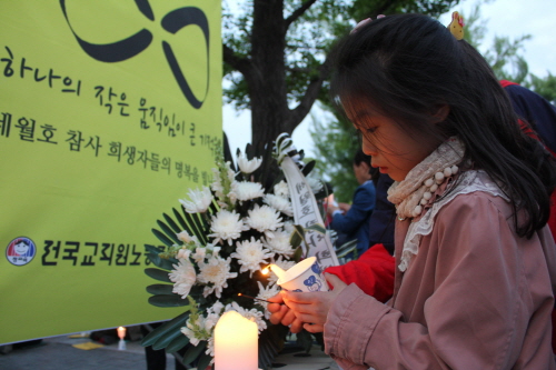 한 아이가 문화제 현장에 임시로 마련된 분향소에서 자신의 촛불을 켰다.