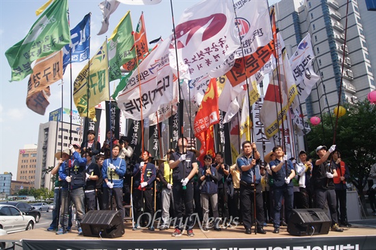 대구시 중구 반월당에서 열린 124주년 세계노동절 대구지역 결의대회에서 만장과 함께 입장한 깃발들이 연단 위에 높게 섰다.