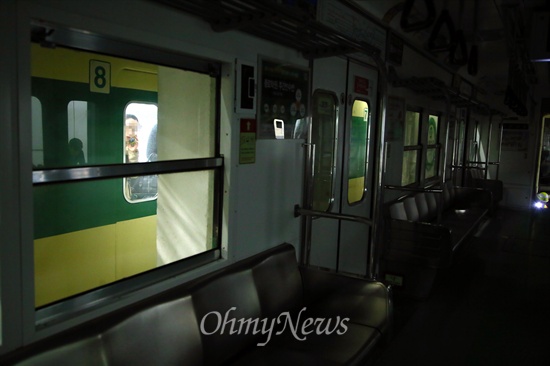추돌사고로 인해 불꺼진 채 멈춰선 객차 옆으로 승객들을 태운 지하철이 지나고 있다.
