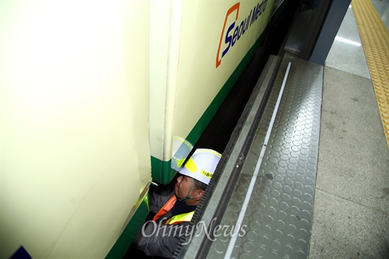 한 노동자가 객차밑에 들어가 점검을 하고 있다.