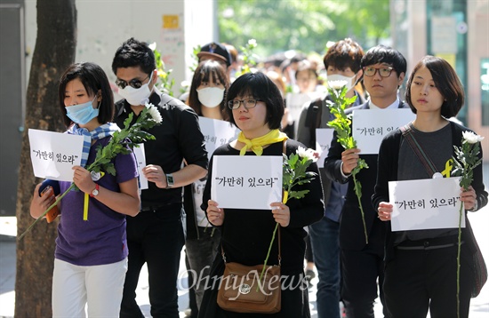  5월 3일 오후 대학생들이 서울 마포구 홍대입구역 부근에서 '가만히 있으라'가 적힌 손피켓과 국화꽃을 들고 침묵시위를 벌이고 있다.