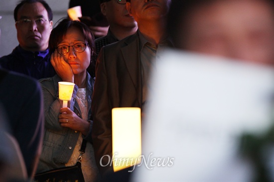 3일 오후 서울 청계천광장에서 열린 세월호 침몰사고 희생자 추모와 실종자 무사귀환을 위한 국민촛불 집회에서 한 참가자가 촛불을 들고 있다.
