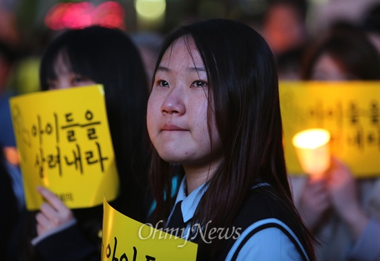 세월호 침몰사고 18일째인 지난 3일 오후 서울 청계광장에서 열린 국정원시국회의 주최 촛불집회에서 참석자들이 학생들의 생전 모습이 담긴 영상을 보며 눈물을 흘리고 있다.