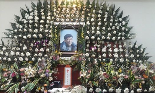 서울대 장례식장. 송국현씨가 시든 꽃 속에서 웃고 있다.