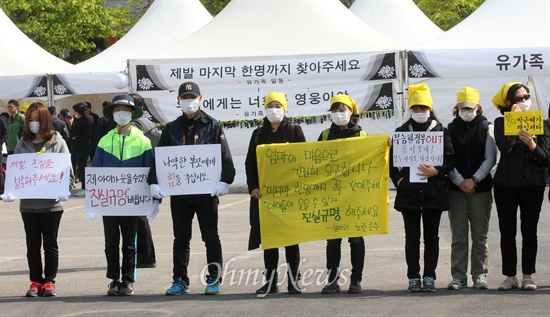 세월호 유가족 침묵시위에 함께하는 '엄마의 노란 손수건' 회원들   안산의 엄마들이 주축이 된 인터넷 카페 '엄마의 노란 손수건' 회원들이 5일 오후 경기도 안산 화랑유원지에 마련된 '세월호 사고 희생자 정부 합동분향소'를 찾아 추모객을 맞이하는 입구 앞에서 유가족들과 함께 세월호 침몰사고 특검 도입과 정부의 철저한 수사, 진상규명을 촉구하는 침묵시위를 벌이고 있다.