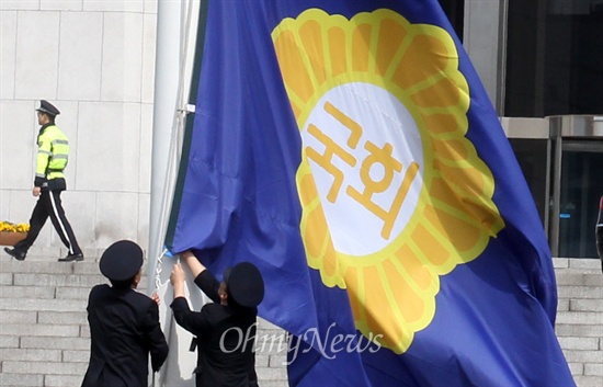 국회 경위들이 지난 2014년 5월 7일 오전 서울 여의도 국회 본청 앞에서 한자(國)를 한글(국회)로 변경된 국회기를 게양하고 있다.