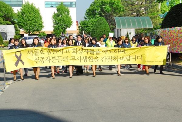 안내 분향소에서 봉사를 하고 있는 중부녹색어머니연합회 회원들이 현수막을 들고 단체를 인솔하고 있다