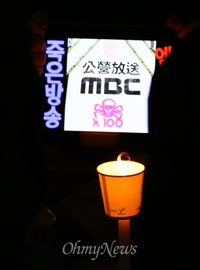 "죽은 방송 MBC" 7일 오후 서울 여의도 MBC 앞에서 열린 세월호 침몰사고 실종자 무사귀환과 희생자 추모 및 MBC 규탄 국민촛불집회에서 한 참가자가 '죽은방송 MBC'가 적힌 테블릿PC를 촛불과 함께 들고 있다.
