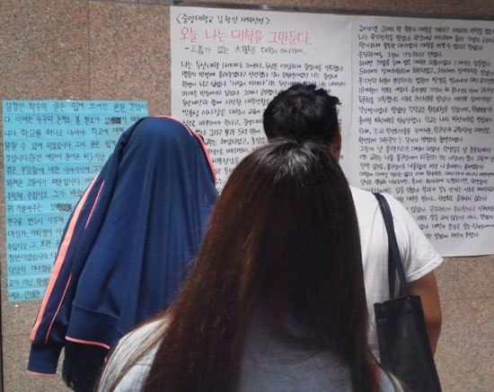 중앙대 학생들이 '오늘 나는 대학을 그만둔다'고 적힌 김창인씨의 대자보를 읽고 있다.
