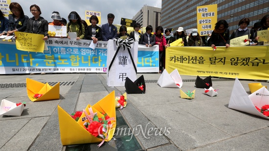  기자회견 참가자들이 카네이션을 달지 않고 종이배에 담아 두었다.