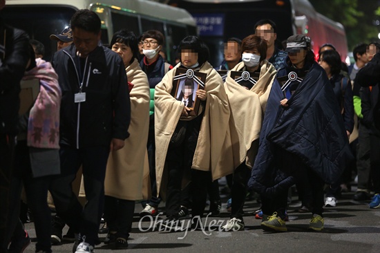 작년 5월, 세월호 참사 유가족들이 안산 합동분향소에서 가져온 영정사진을 품은 채 박근혜 대통령 면담을 요구하며 청와대를 향해 걸어가고 있다.