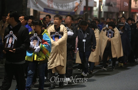 세월호 참사 유가족들이 안산 합동분향소에서 가져온 영정사진을 품은 채 9일 새벽 박근혜 대통령 면담을 요구하며 청와대를 향해 걸어가고 있다.