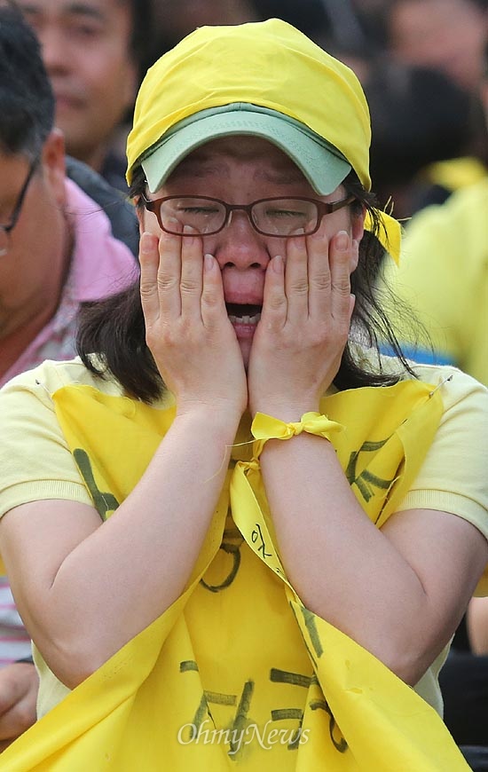 '어떻게 이런 일이...' 노란손수건 엄마의 눈물 세월호 참사 25일째인 10일 오후 경기도 안산문화광장에서 학생, 시민들이 모인 가운데 '세월호 희생자 추모와 진실을 밝히는 국민촛불행동'이 열렸다. 세월호 참사로 희생된 단원고 학생들의 생전 모습이 모니터에 비치자 '엄마의 노란손수건' 카페 회원이 눈물을 흘리고 있다.
