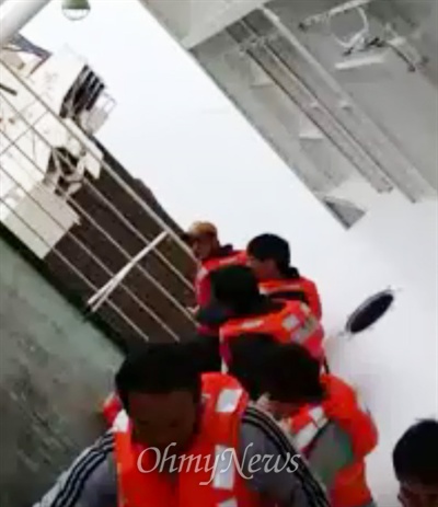 세월호 생존자 김동수씨가 사고 당일 오전 9시 24분쯤 촬영한 동영상 갈무리. 승객들이 가파른 갑판 위에 위태롭게 매달려 있다.