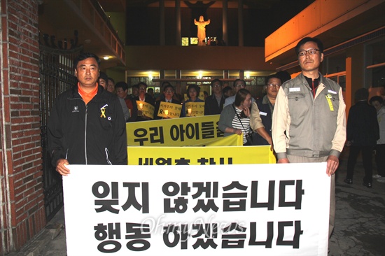  14일 저녁 경남 창원 천주교 진해중앙성당에서 '세월호 참사 희생자 진해지역 합동추모미사'가 열렸다. 미사 참가자들은 "잊지 않겠습니다. 행동하겠습니다"라고 쓴 펼침막과 촛불을 들고 거리행진을 했다.