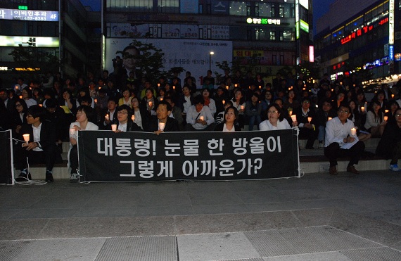  안산문화광장에서 열린 교사촛불에 참가한 교사들이 '대통령! 눈물 한 방울이 그렇게 아까운가?'라고 쓴 펼침막을 들고 있다. 