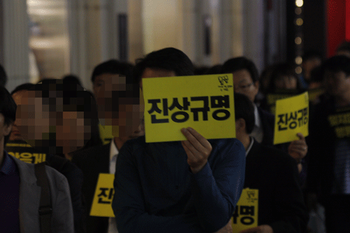 세월호 참사 30일을 맞아 시민들이 '진상규명'이라고 적힌 종이피켓을 들고 거리행진을 하고 있다.
