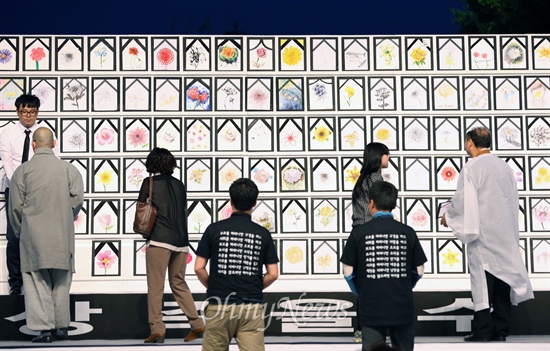 17일 저녁 광주시 동구 금남로에서 열린 5.18 민중항쟁 34주년 민주대성회에 세월호 참사 희생자와 실종자를 상징하는 304개의 꽃그림 영정을 든 광주 시민들이 입장하고 있다.