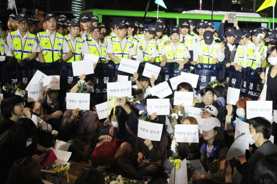 세월호 침묵시위를 하던 경찰에 둘러쌓여 가만히 있는 모습. 용혜인씨는 경찰이 침묵행진을 막자 "추모하는 게 죄라면 우리를 잡아가십시오!"라고 외쳤다.