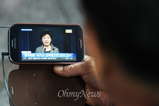 지난달 19일 오전 서울역 승강장에서 시민들이 TV를 통해 박근혜 대통령의 대국민 담화문 발표를 지켜보고 있다.