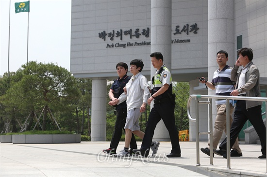 '박정희 대통령 기념·도서관'에서 기습시위를 벌이던 '청년좌파' 회원이 경찰에 연행되고 있다.