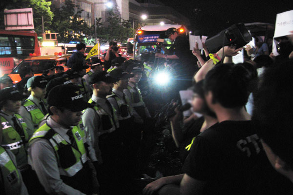 광장 가장자리 화단을 사이에 두고 마주선 경찰들과 학생들.