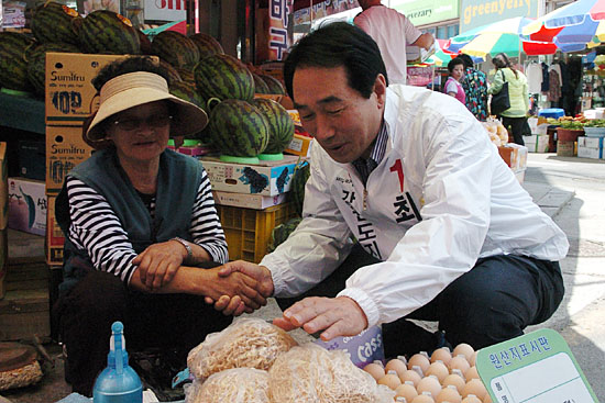 21일 홍청중앙시장에서 시장 상인과 이야기를 나누고 있는 최흥집 후보.