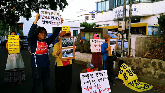 강정마을 일부주민과 해군기지 반대활동가들이 원희룡 새누리당 제주도지사 후보의 방문을 반대하며 마을회관 앞에서 손팻말을 들고 있다. 