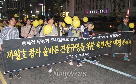 세월호 참사의 진상규명 등을 촉구하는 부산시민들의 시국대회가 23일 저녁 부산역광장에서 열렸다. 집회 참가자들이 플래카드를 들고 행진하고 있다. 