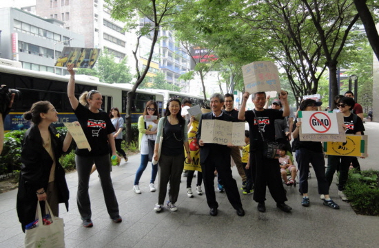 "GMO 기업 물러가라!" 구호를 외치고 있는 참가자들