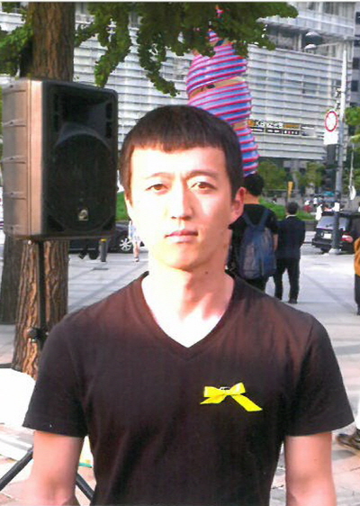 김후보가 선관위에 제출한 후보 사진. 선관위에 신고한 선거사무소인 청계광장에서 노란 리본을 달고 찍었다.