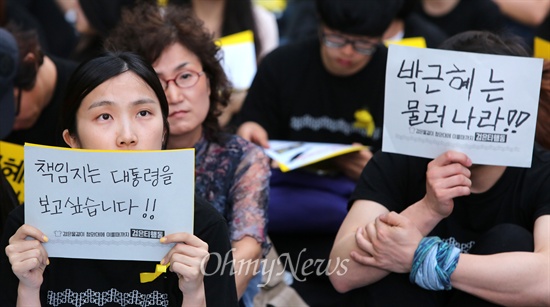 시민들이 세월호 참사와 관련해서 박근혜 대통령의 책임을 묻는 손피켓을 들고 있다.