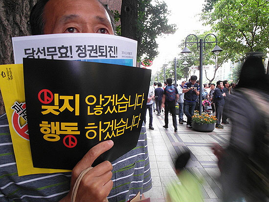 24일 서울 청계광장에서 열린 '세월호 참사 추모 촛볼집회'에 참석한 한 시민이 푯말을 들고 있다. 푯말 안에는 투표 기호가 그려져있다. 