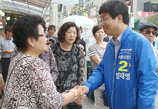  '조용하고 깨끗한 정책선거를 치르겠다'고 약속한 염태영 후보가 최근 수원 팔달문 근처 '차 없는 거리'에서 만난 시민과 악수하며 대화를 나누고 있다. 
