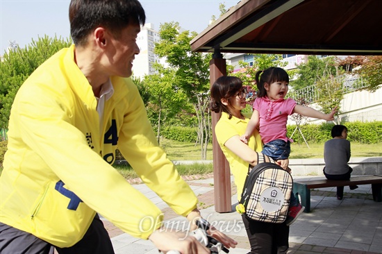 6월 지방선거에서 광주 남구의원 후보로 출마한 임승호 후보가 28일 자전거를 타고 유안근린공원을 돌며 주민들과 만나고 있다. 한 아이가 임 후보의 기호인 "4번"을 외치며 손가락을 펴 보이고 있다.