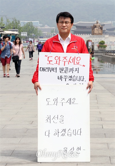 6.4 지방선거가 3일 앞으로 다가온 가운데 윤상현 새누리당 사무총장이 1일 오전 서울 광화문 광장에서 "도와주세요" 피켓을 들고 새누리당 지지를 호소하고 있다. 