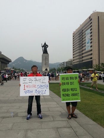 1일 조동원 새누리당 홍보기획본부장이 '도와주세요' 1인 피켓 유세를 펼치는 가운데, 평화를 위한 기독인 연대 소속 김지수(32)씨가 바로 옆에서 '박근혜 퇴진' 1인 시위를 진행하고 있다. 